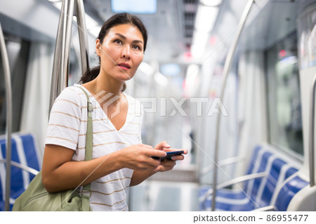 Woman with smartphone in subway train Woman with smartphone in subway train 86955477