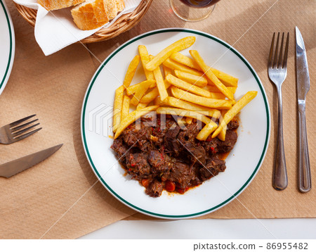 Wild boar in sauce with french fries Wild boar in sauce with french fries 86955482
