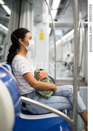 Woman in face mask in subway train 86955569