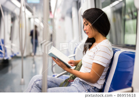 Woman reading book in subway train 86955618