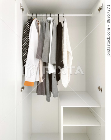 Basic clothes in white wardrobe. Neutral colors 86957271