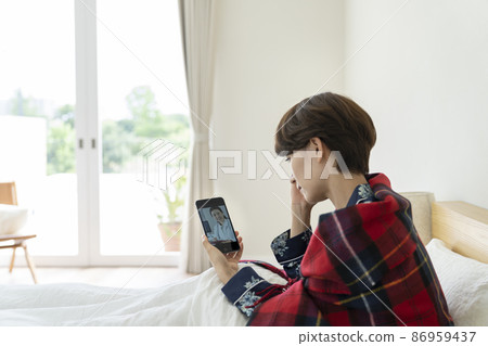 一名中年婦女在智能手機上接受在線醫療的圖像 86959437