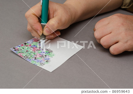 A woman's manicure-less hand draws an abstract drawing with a pen. A woman's manicure-less hand draws an abstract drawing with a pen. 86959643