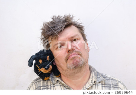 Portrait of a humorous male with a dog toy on his shoulder. 86959644