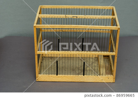 Old wooden birdcage on gray background. Old wooden birdcage on gray background. 86959665