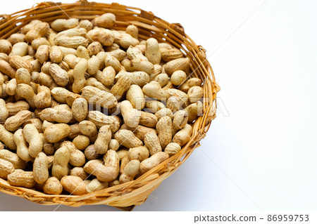 Raw peanuts in bamboo basket on white background. Raw peanuts in bamboo basket on white background. 86959753