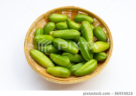 Bilimbi fruit in bamboo basket on white background. 86959828