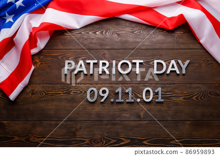 the words patriot day laid with silver metal letters on wooden board surface with crumpled usa flag 86959893