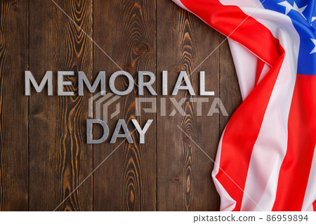 the words memorial day laid with silver metal letters on wooden board surface with crumpled usa flag 86959894
