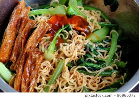 Quick and cheap vegan food for breakfast from instant noodles 86960372