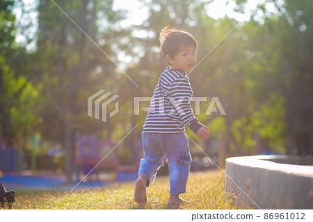 Aorable little boy running on green grass in morning park sun rise Aorable little boy running on green grass in morning park sun rise 86961012