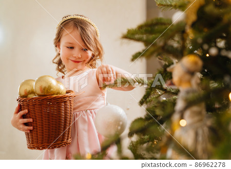 a cute little girl with toy basket for the Christmas tree. a cute little girl with toy basket for the Christmas tree. 86962278