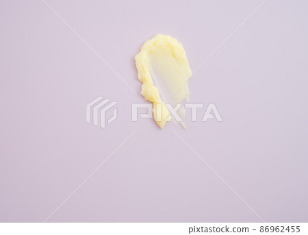 Cosmetic products creamy yellow stain texture on pink background. Texture of natural cosmetics, hair mask, cream, scrub. Cosmetic products creamy yellow stain texture on pink background. Texture of natural cosmetics, hair mask, cream, scrub. 86962455