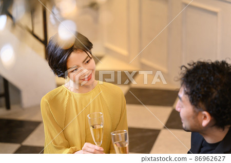 A bird's-eye view of a couple at the bar, with a blur in front of the chandelier A bird's-eye view of a couple at the bar, with a blur in front of the chandelier 86962627