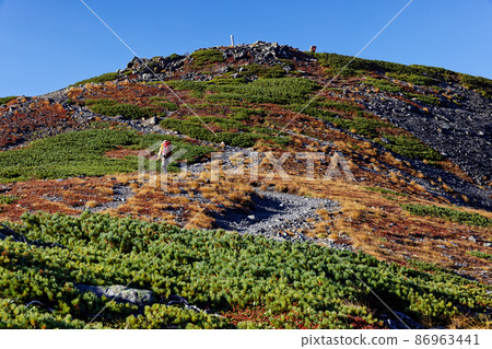 Climbers going along the autumn-colored Southern Alps and Mt. Aino ridgeline 86963441