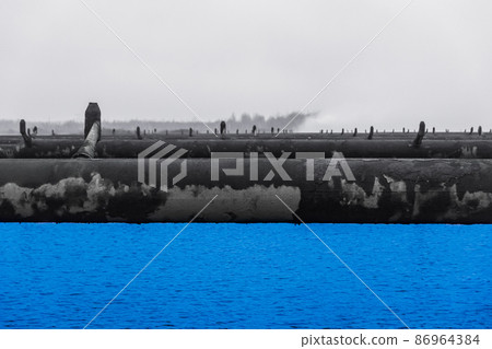 Old steel rusty abandoned pipes of the water cooling pipeline system of the combined heat and power industrial plant Old steel rusty abandoned pipes of the water cooling pipeline system of the combined heat and power industrial plant 86964384