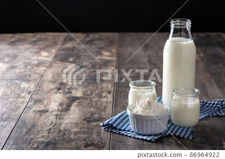 Milk kefir drink on wooden table. Liquid and fermented milk product Milk kefir drink on wooden table. Liquid and fermented milk product 86964922
