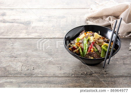 Beef, vegetables and sesame seeds in black bowl Beef, vegetables and sesame seeds in black bowl 86964977