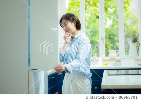 A woman who is worried about opening the refrigerator 86965791