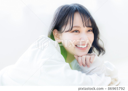 A young woman lying down and relaxing in the living room A young woman lying down and relaxing in the living room 86965792