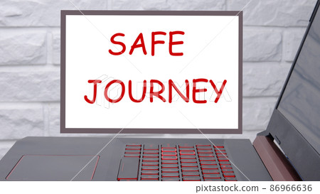 Safe journey a phrase written on a magnetic board next to a laptop with a glowing keyboard 86966636