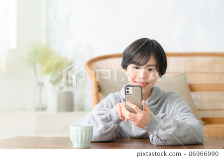 A woman staring at a smartphone with a copy space in front 86966990