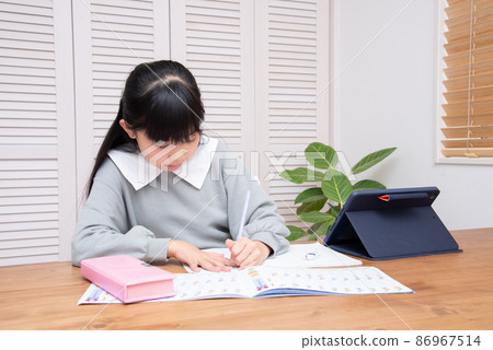 Girl doing homework using a tablet 86967514