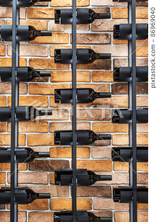 Wine bottles stacked on an iron rack in a wine cellar Wine bottles stacked on an iron rack in a wine cellar 86969040