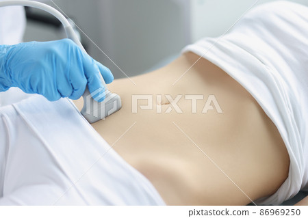 Hands on a woman's stomach, ultrasound abdominal cavity 86969250
