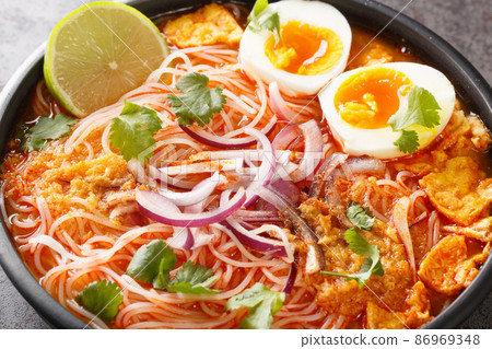 Mohinga is a rice noodle and fish soup from Myanmar and an essential part of Burmese cuisine closeup in the bowl. Horizontal 86969348