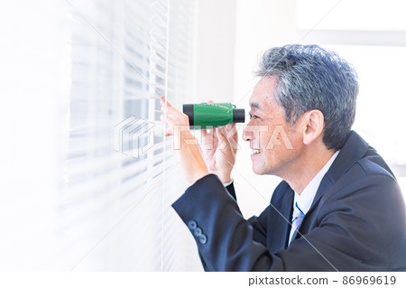 A businessman looking out with binoculars A businessman looking out with binoculars 86969619