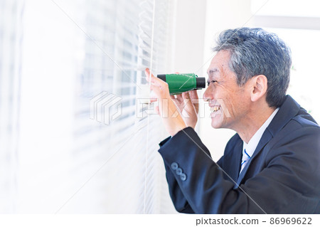 A businessman looking out with binoculars A businessman looking out with binoculars 86969622