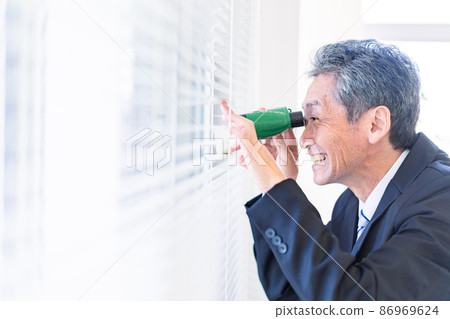 A businessman looking out with binoculars A businessman looking out with binoculars 86969624