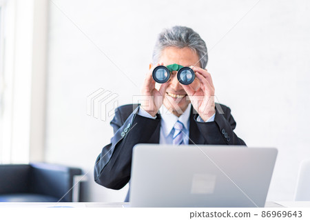 A businessman looking out with binoculars A businessman looking out with binoculars 86969643