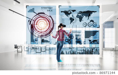 Girl in office interior in virtual reality mask using innovative technologies. Mixed media 86971144