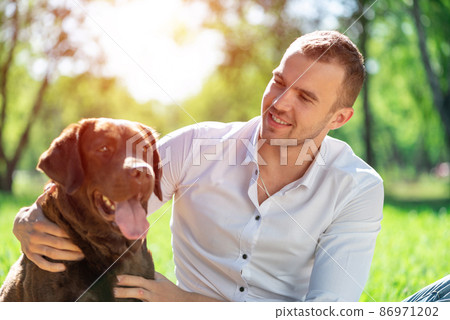Young man with a dog in the park 86971202