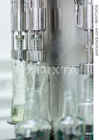 Bottles with a drink closed with a screw cap. Factory for the production of alcoholic beverages Bottles with a drink closed with a screw cap. Factory for the production of alcoholic beverages 86973456