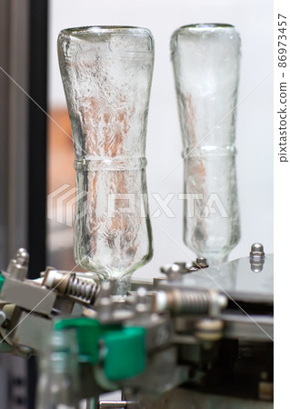 The machine for washing glass bottles. Factory for bottling alcoholic beverages. The machine for washing glass bottles. Factory for bottling alcoholic beverages. 86973457