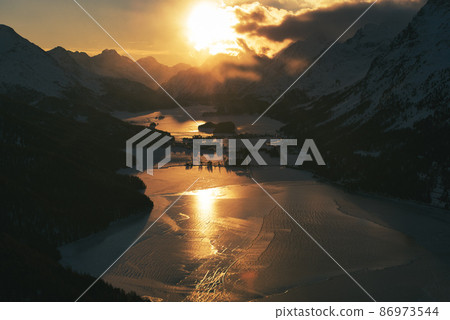 Colorful sunset over the frozen lakes of the Swiss alps at the Maloja pass Colorful sunset over the frozen lakes of the Swiss alps at the Maloja pass 86973544