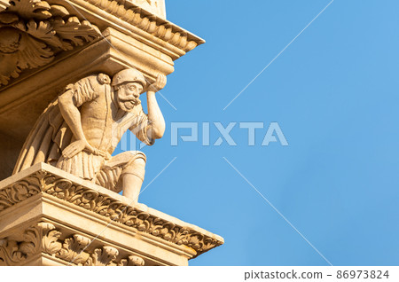 Lecce, Puglia, Italy. August 2021. The church of Santa Croce is the finest example of Lecce baroque. Detail of the facade illuminated by the warm light of the evening. 86973824