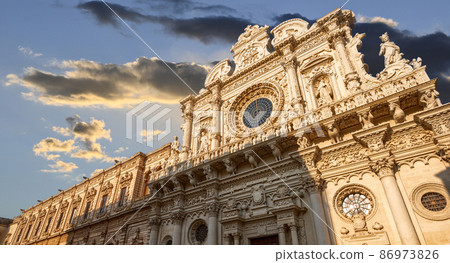 Lecce, Puglia, Italy. August 2021. The church of Santa Croce is the finest example of Lecce baroque. The view displays it in all its beauty with late afternoon light. People. 86973826