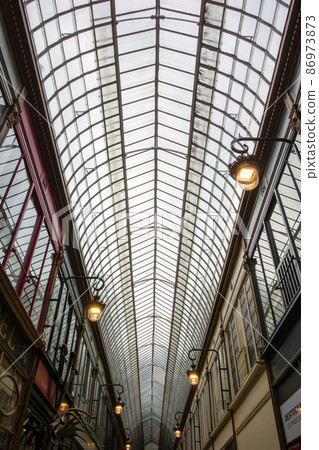 巴黎街頭設有商店和雕刻鐘錶的玻璃拱廊 86973873