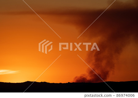 Fire smoke over the orange horizon at sunset 86974006