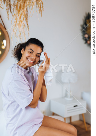 African american woman takes care of her skin in the bathroom 86976784