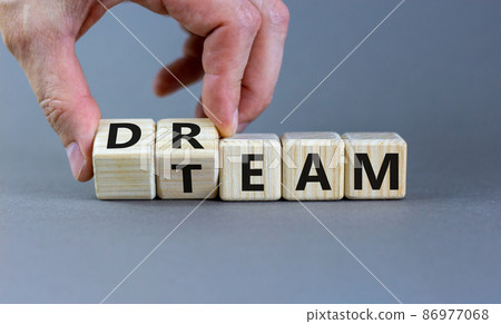 Dream team symbol. Businessman turns cubes and changes the word 'dream' to 'team'. Beautiful grey table, grey background. Business and dream team concept, copy space. Dream team symbol. Businessman turns cubes and changes the word 'dream' to 'team'. Beautiful grey table, grey background. Business and dream team concept, copy space. 86977068