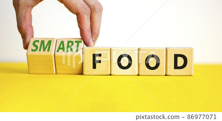 Smart food symbol. Doctor turns cubes and changes words 'food' to 'smart food'. Beautiful yellow table, white background. Medical, smart food concept. Copy space. 86977071