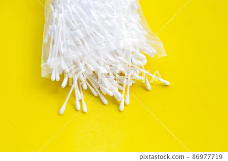 Cotton buds on yellow background. Cotton buds on yellow background. 86977719
