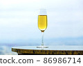 Champagne glass and copy space that blends into the light blue landscape 86986714