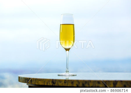 Champagne glass and copy space that blends into the light blue landscape Champagne glass and copy space that blends into the light blue landscape 86986714