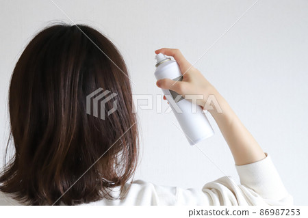 Female spraying hair 86987253